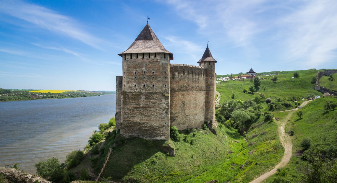 old fortress on green hills near river