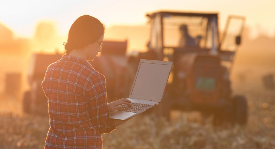 Lady checking the information in PC at the field