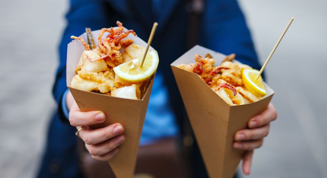 Person holding street food in cones