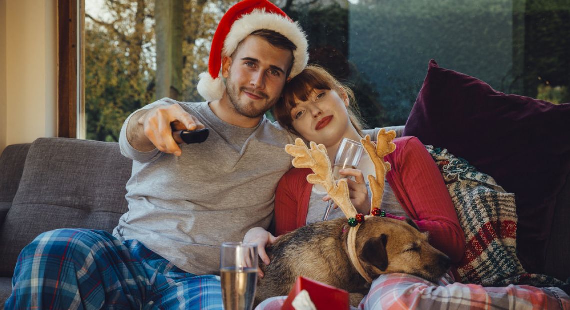 Couple watching TV with a dog