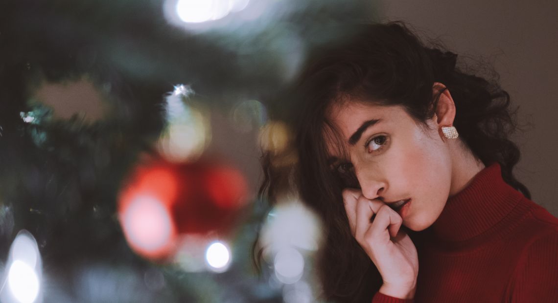Girl standing by the Christmas tree