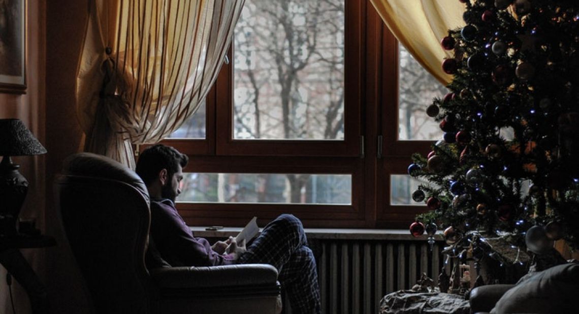 Man sitting by the Christmas tree