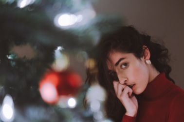 Girl standing by the Christmas tree