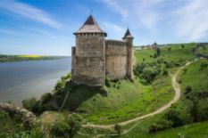 old fortress on green hills near river