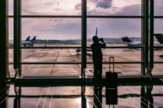Man taking a picture of an airplane in an airport