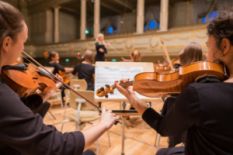 musicians playing violins in orchestra