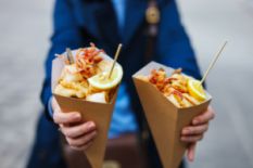 Person holding street food in cones