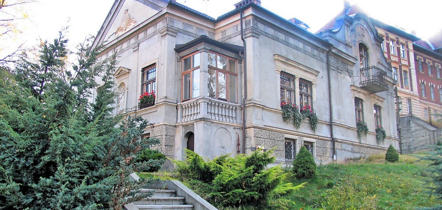 old mansion with stairs surrounded by greenery