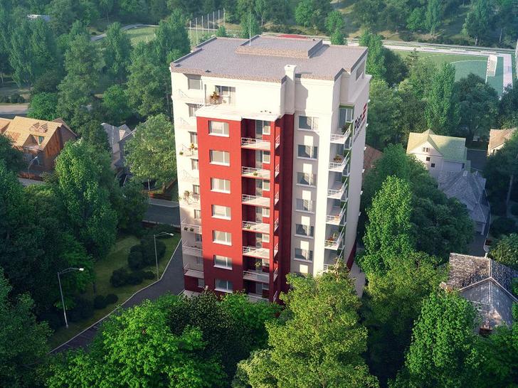 high multi-storey building surrounded by smaller buildings and trees