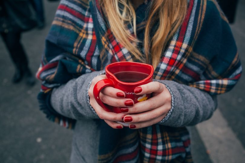 girl holding paper glass with hot wine