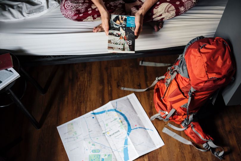 Girl sitting in a hostel with a travel guide