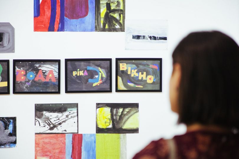 girl looking at paintings at exhibition