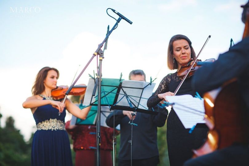 musicians playing violins open air