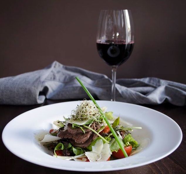 glass of wine and dish with salad