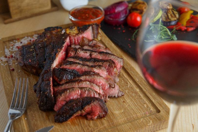 meat dish and glass of red wine