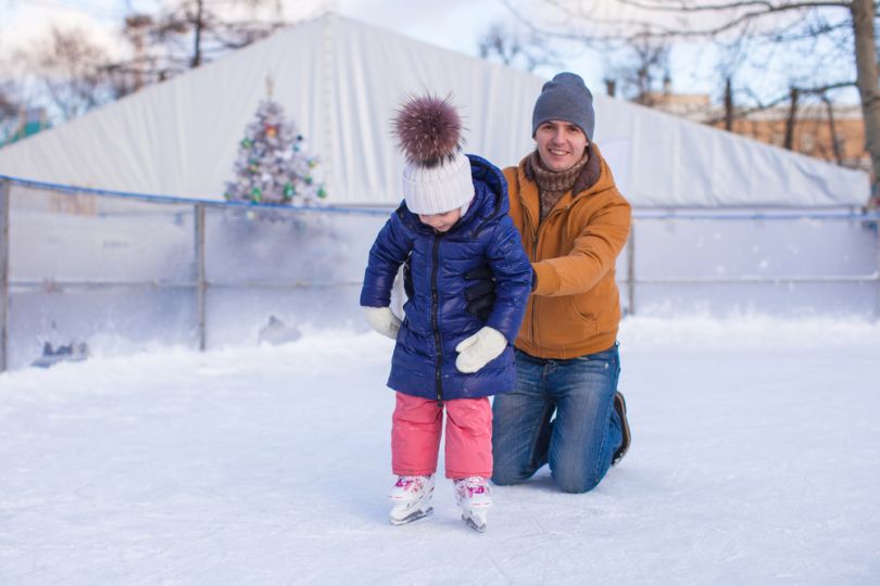 Father helping his kid on ice