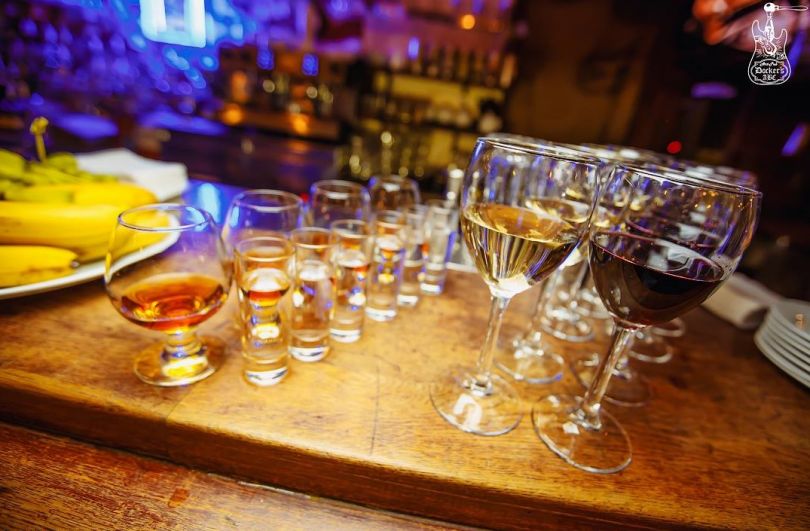 bar counter with glasses with whiskey and wine