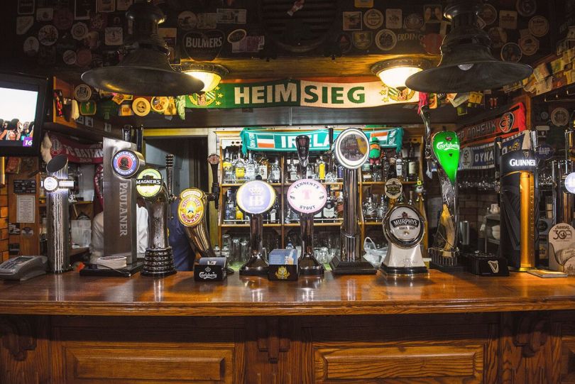 bar counter with signs, bottles and beer