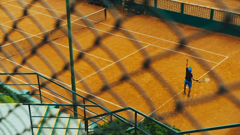 Man playing tennis on a large court